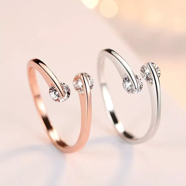 Este elegante anel de noivado para mulheres, banhado a ouro rosa e ostentando um design de moda, é uma escolha encantadora para ocasiões especiais. Com dois zircônios cúbicos delicadamente incorporados, o anel exala sofisticação e romantismo. A beleza brilhante dos cristais de zircônia cúbica adiciona um toque de glamour, proporcionando um brilho deslumbrante ao dedo da noiva. O banho de ouro rosa confere uma tonalidade suave e moderna, complementando perfeitamente o design contemporâneo do anel. Este anel não é apenas uma peça de joia, mas um símbolo significativo de compromisso e amor. Sua atenção aos detalhes e acabamento impecável fazem dele uma escolha única para o momento especial do noivado. A referência específica R007 destaca a exclusividade deste item. Seja para celebrar uma proposta romântica ou renovar os votos, este anel de noivado cativante é uma expressão atemporal de carinho e comprometimento.
